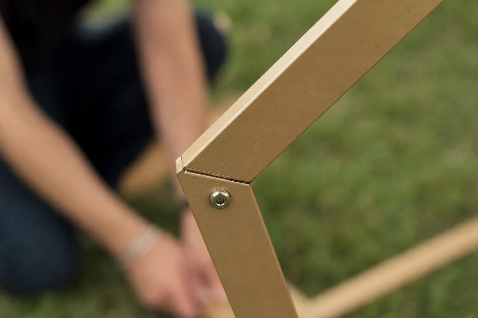 Close-up of a gold metal arch corner joint and locking bolt