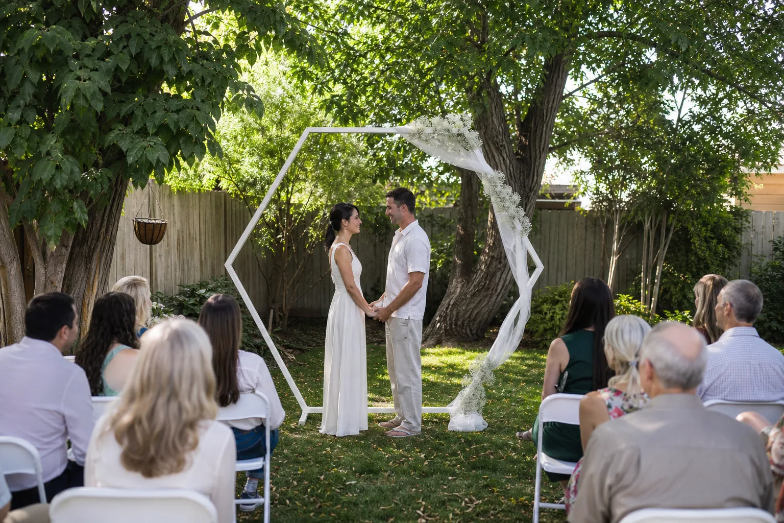 Compact matte-ivory open-hexagon arch at an intimate backyard wedding