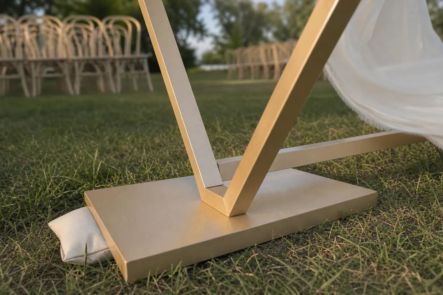 Low rectangular base plate supporting a gold arch on grass